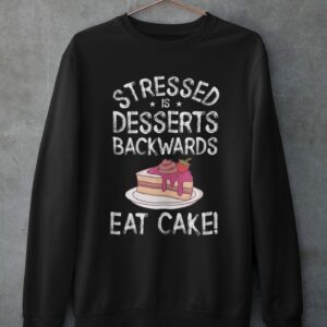 Stressed Is Desserts Spelled Backwards Eat Cake Unisex Heavy Blend™ Crewneck Sweatshirt - mockup of a customizable crewneck sweatshirt hanging against a concrete wall - Shujaa Designs
